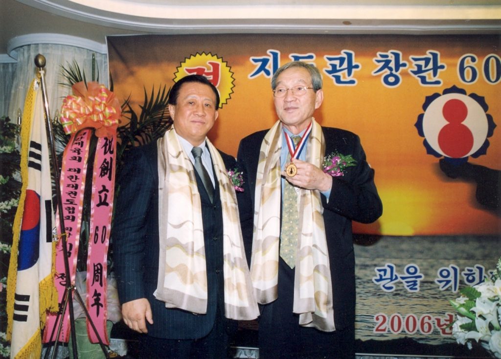 In 2006, Lee Seng-wan (on left) presented an award to Lee Chong-woo, a leader of Olympic Taekwondo who had once lamented that he was a sinner for allowing so many gangsters into the Kukkiwon and WTF.